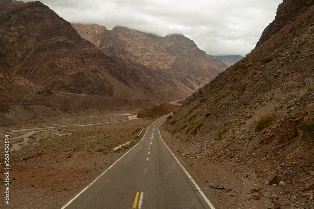 Traveling along the asphalt road in the mountains and desert on the way to mount Aconcagua. 