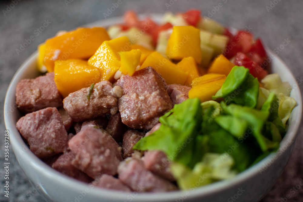 Plato de ensalada con atún fresco, mango y verduras Plato de ensalada con atún fresco, mango y verduras