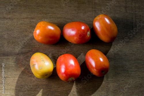 A few Fresh tomatoes at the rustic table.
