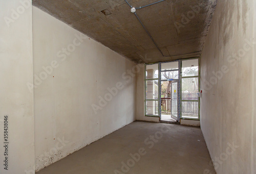 A small room without renovation for decoration. New building. The walls are plastered, the floors are concreted. There is a posting. For final finishing