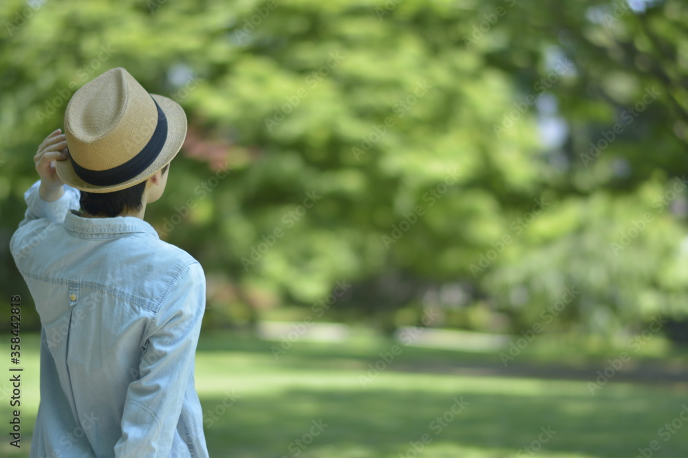 Asian young women.  like spending time in the middle of nature.   wear a hat at a rakish angle.  blurred background with copy space.