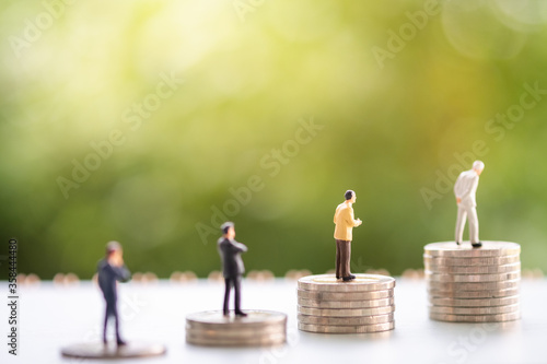 Miniature people: Business man stack of coins with copy space for text using as background saving, investment, money, financial, business analytics concept.