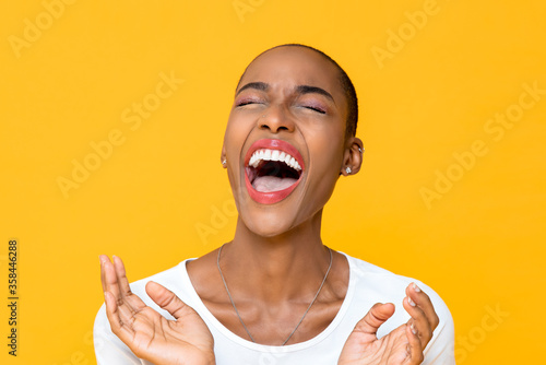 Fototapeta Close up portrait of happy young African American woman laughing out loud with b