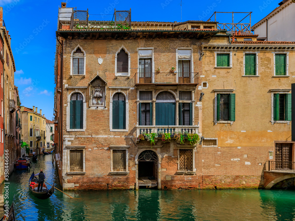 Gondola passing along buildings in a canal in Venice Italy