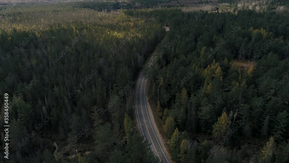 Aerial tilt reveal of highway through green New Hampshire forest in fall Aerial tilt reveal of highway through green New Hampshire forest in fall
