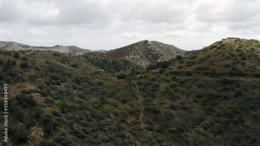 Aerial tilt reveal of hiking trails in green mountain valley near Los Angeles Aerial tilt reveal of hiking trails in green mountain valley near Los Angeles