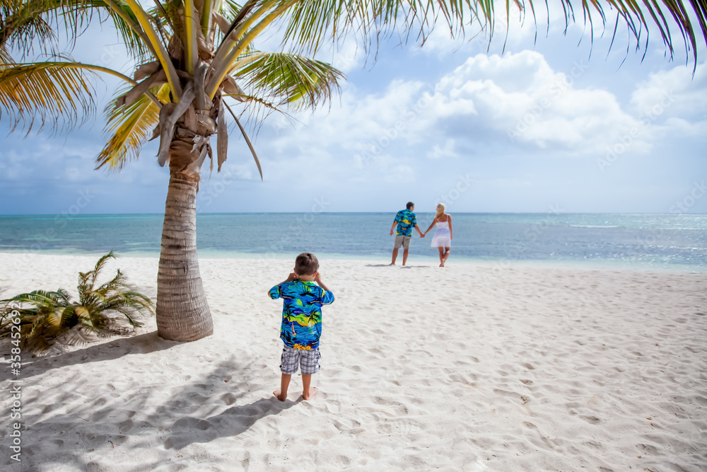 Family having fun and enjoying the white sandy beach on sunny day. Summer vacation for family in tropical paradise caribbean island coast, touristic destination for family vacations and leisure