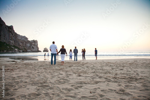 multi-generational family standing on the beach. Family looking out toward the water. 
