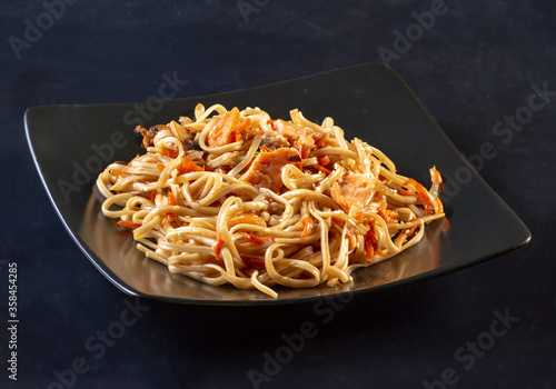 Foto Dish of Japanese cuisine udon vermicelli on a black ceramic plate on a black background