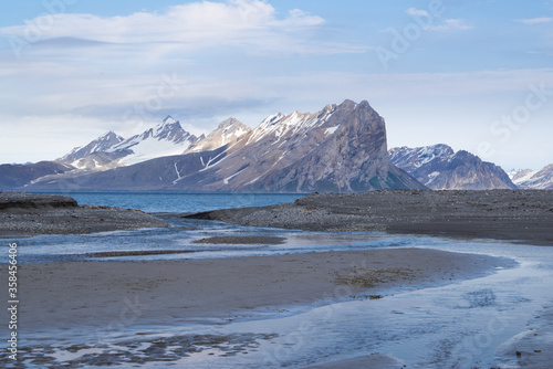 Wonderful scenic landscape over "Hornsund" on Spitsbergen. Pointy mountains and melting water streams in the foreground.