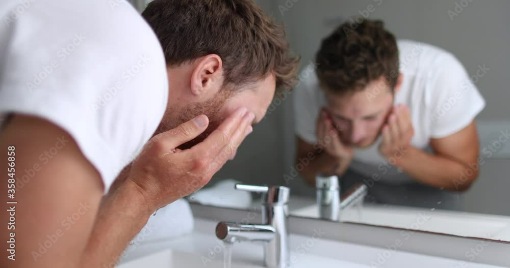 Man washing face rinsing soap from skin in sink under running cold water from faucet, Morning skincare routine. Male beauty skin care facial wash. Mask treatment. 4K (UHD) 59.94 FPS SLOW MOTION. Man washing face rinsing soap from skin in sink under running cold water from faucet, Morning skincare routine. Male beauty skin care facial wash. Mask treatment. 4K (UHD) 59.94 FPS SLOW MOTION.