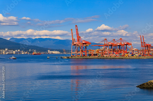 Vancouver harbour with red gantry cranes and cargo shipping containers at the Centerm terminal on the waterfront, Canada photo