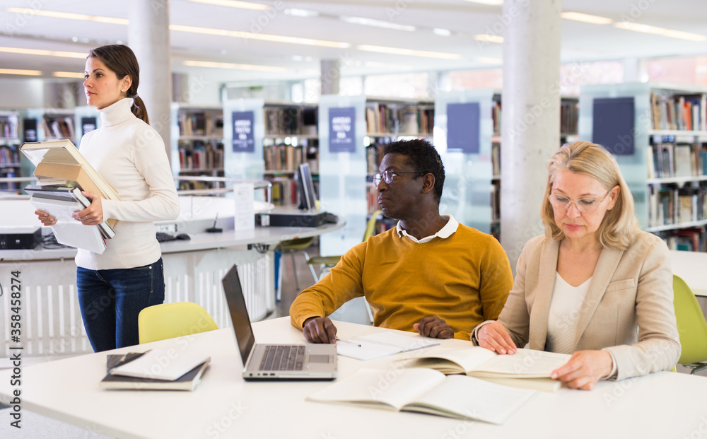 Obraz premium Professor and students communicate in the library