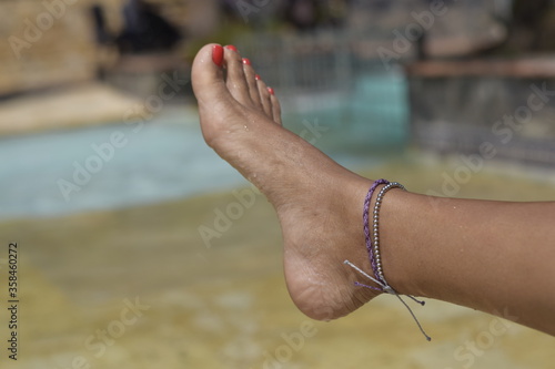 woman's feet in summer wearing an ankle brace in the pool