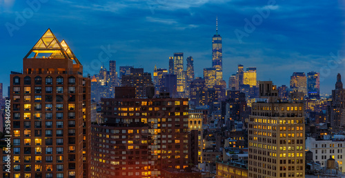 Aerial view of the iconic skyline and skyscrapers of New York Lower Manhattan on a cloudy day after sunset