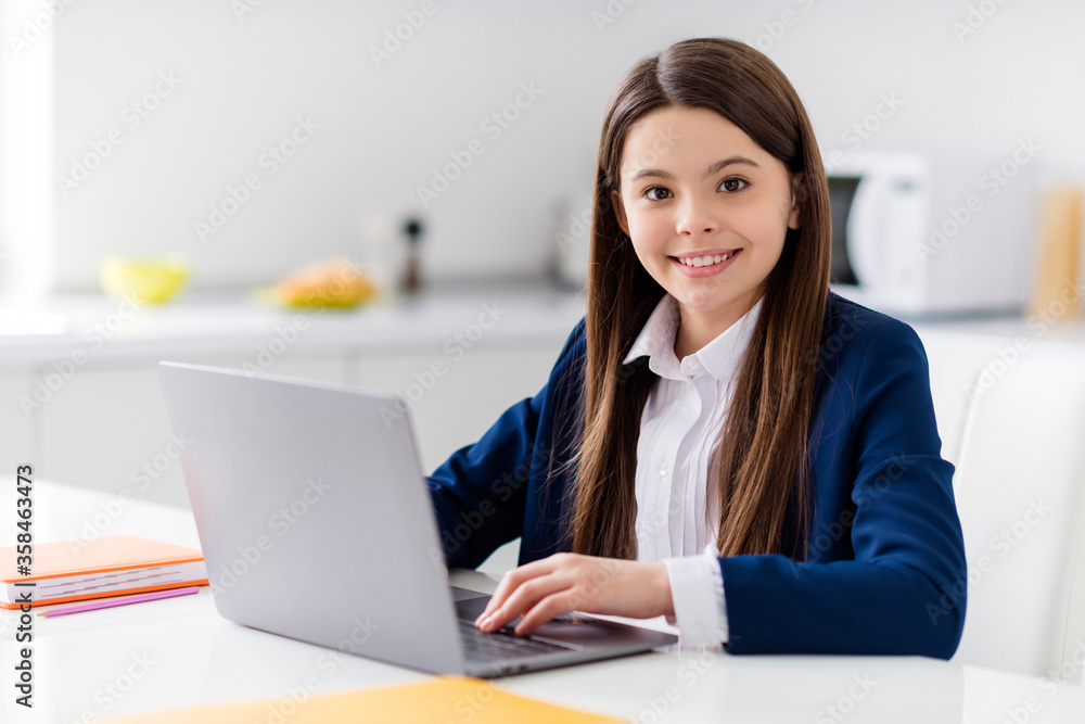 Photo of little cheerful pretty student girl diligent student notebook online lesson video call sit desk distance quarantine study september at home living room house classroom indoors Photo of little cheerful pretty student girl diligent student notebook online lesson video call sit desk distance quarantine study september at home living room house classroom indoors