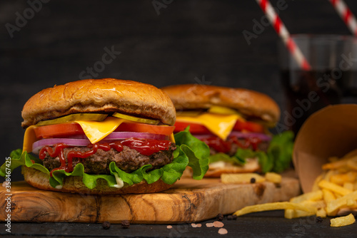 Burger or hamburger on a wooden background with french fries and cola, fast food