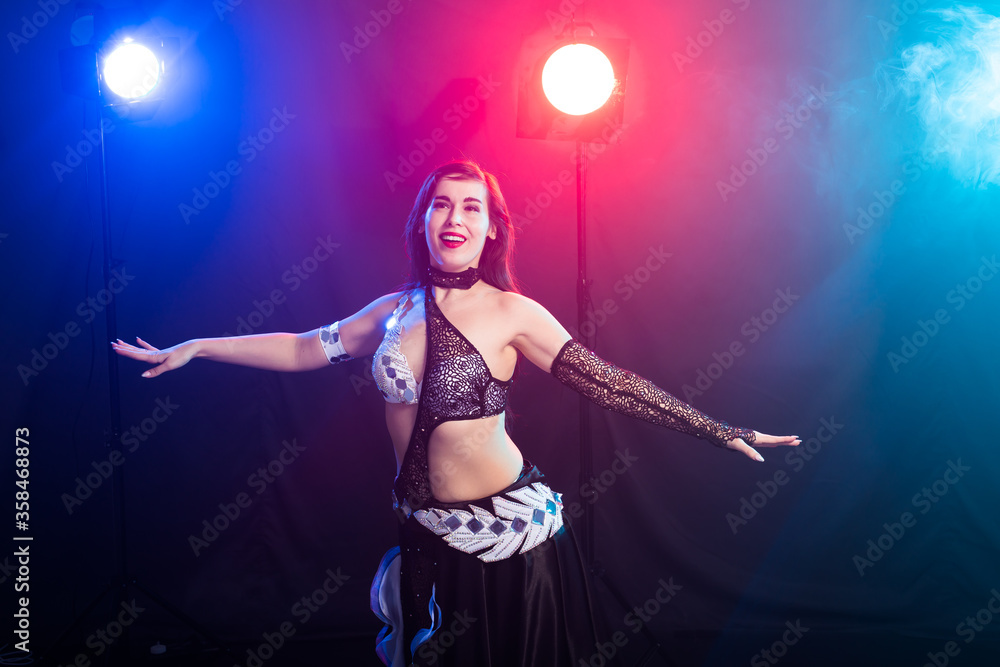 Girl dancing belly dance, fusion or tribal. A woman in a beautiful costume demonstrates charming and gentle movements in the dance.
