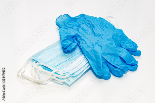 Medical masks and blue lnitrile medical gloves on white background © Irina Rogova