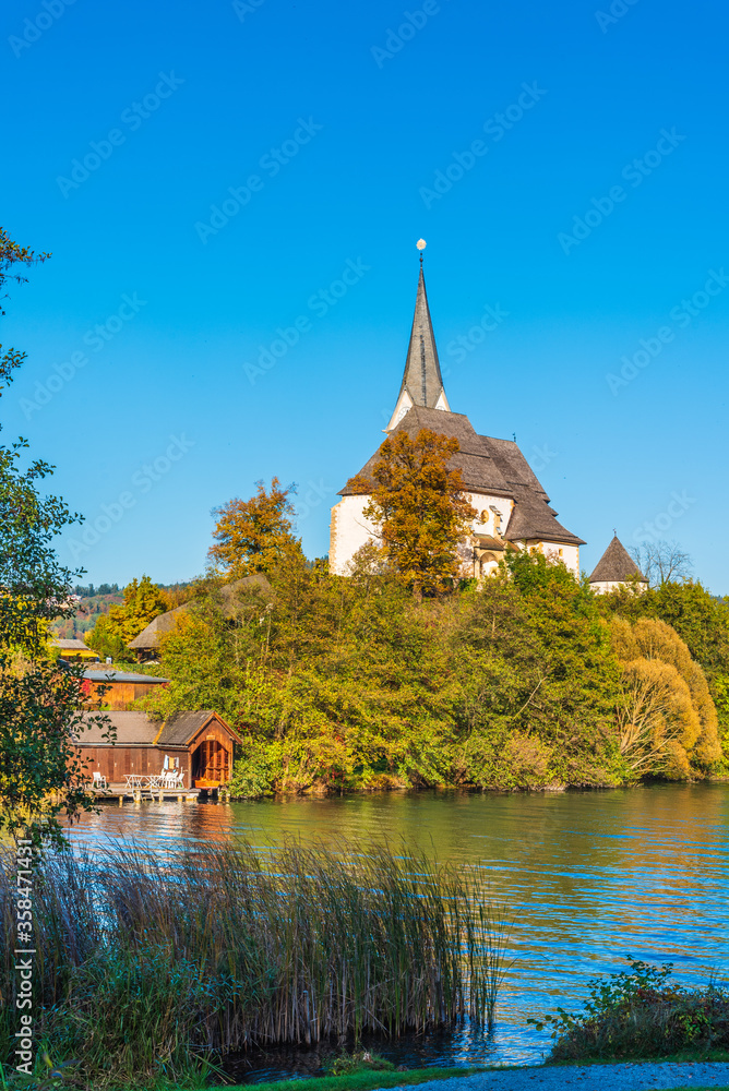 Magical Gothic architecture in Austria. Panorama on Lake Worthersee. Maria Worth church and sanctuary.