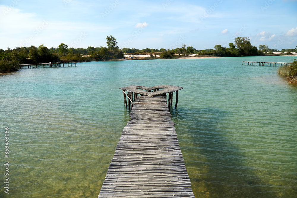 Naklejka premium Wide angle view of wooden bridge at blue lake