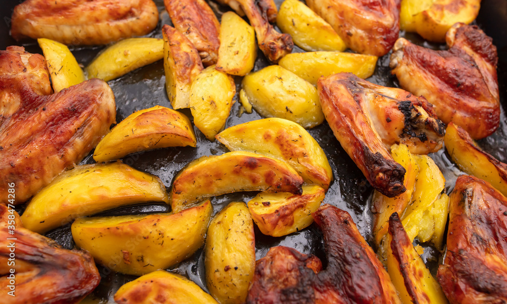 Baked chicken and potatoes in the oven as a background. Baked chicken and potatoes in the oven as a background.