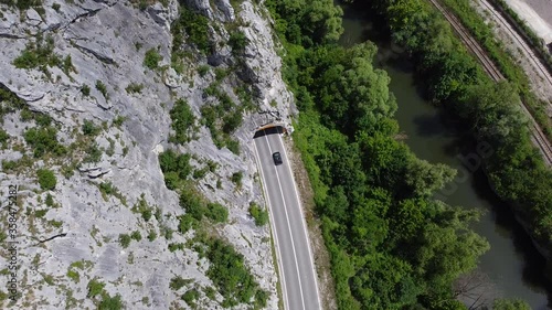 Aerial view of traffic road and tunnel in the mountain next to river 