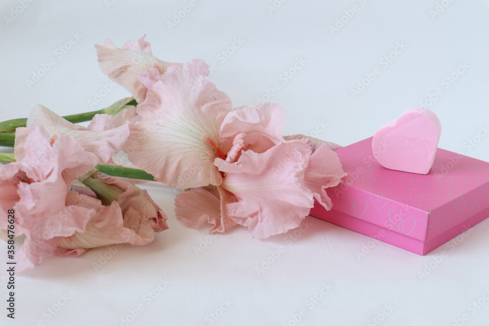  Gift box with a delicate pink heart and a bouquet of irises on a white background, close-up, place for the inscription