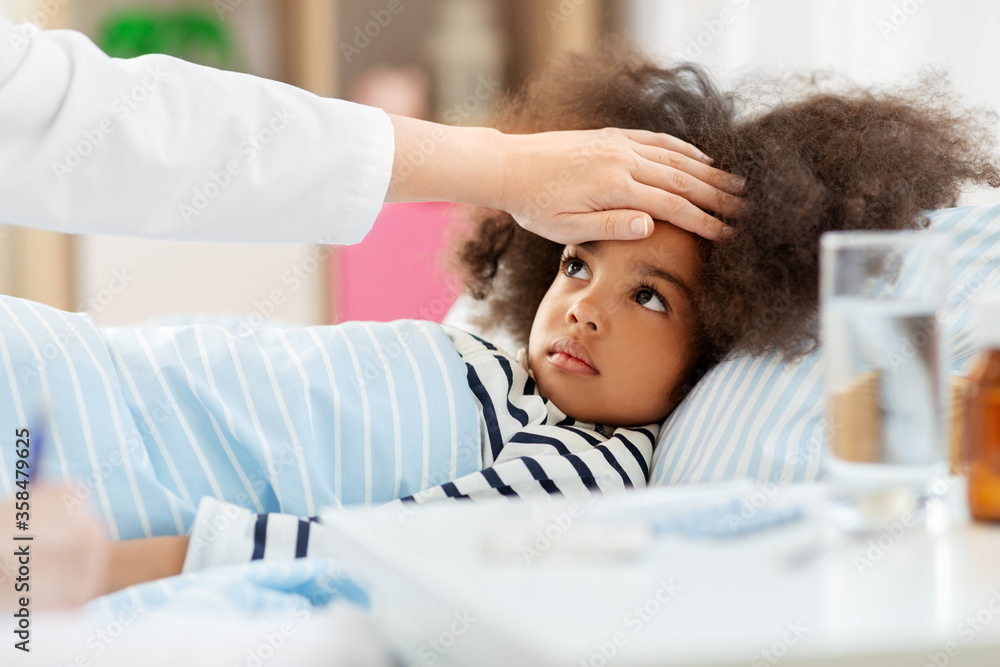 Fototapeta premium healthcare, medicine and people concept - doctor with clipboard and little sick african american girl lying in bed at home