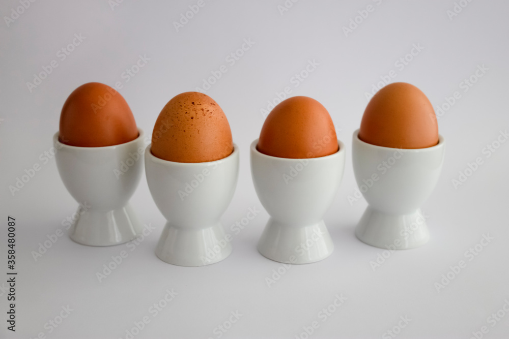 Four boiled eggs in egg cups, on white background Four boiled eggs in egg cups, on white background