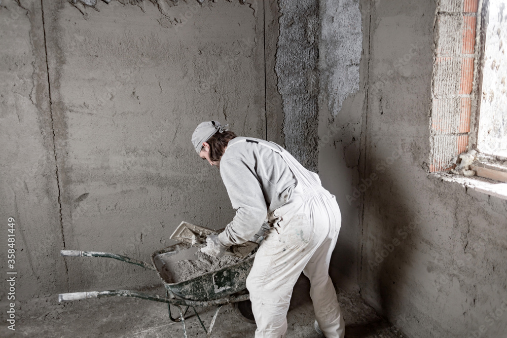 Real construction worker making a wall inside the new house.