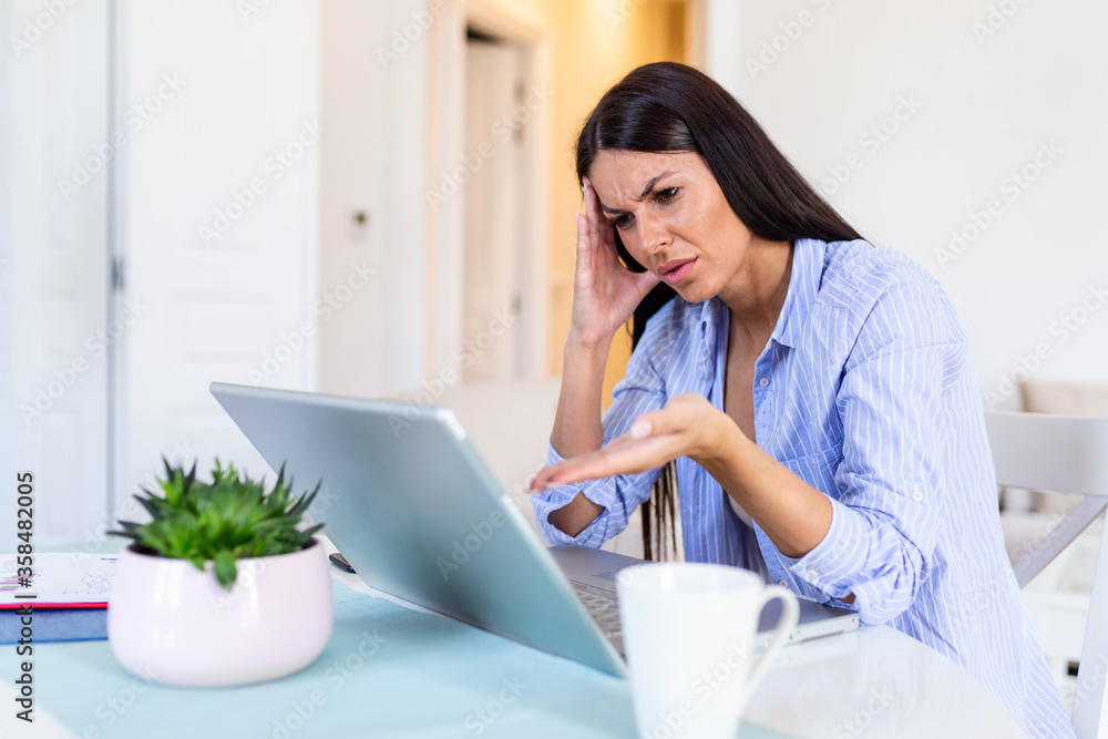 Young businesswoman misunderstanding her laptop at her desk in office. woman working with laptop at home or modern office. Serious, confused, or frustrated expression. Young businesswoman misunderstanding her laptop at her desk in office. woman working with laptop at home or modern office. Serious, confused, or frustrated expression.