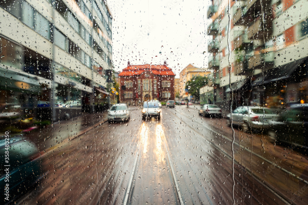 Rain drops on the window with streets of Helsinki, Finland