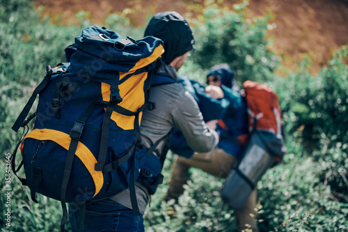 Two handsome men with backpacks on standing in beautiful nature and searching a good place for tent. Camping on weekend concept.