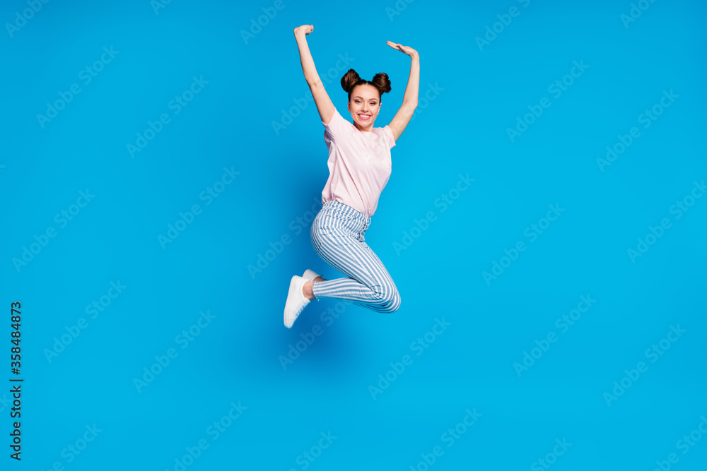 Full length body size view of her she nice attractive pretty charming cheerful cheery girl jumping having fun rejoicing rising hands up isolated on bright vivid shine vibrant blue color background