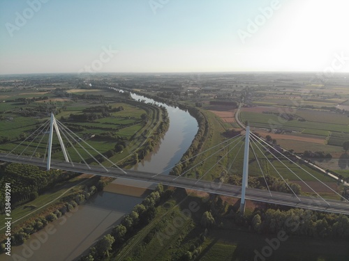 Aerial view of a modern bridge over a river in northern Italy.