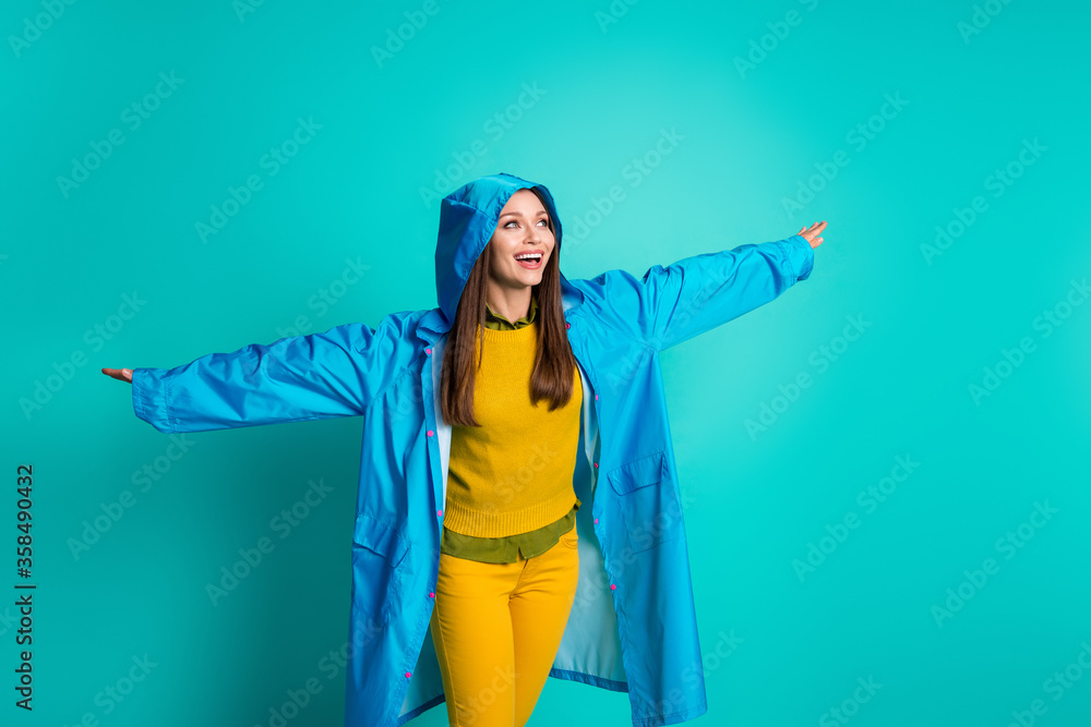 Photo of attractive funny lady cheerful mood spread arms like wings rainy weather street walk rejoicing wear casual outfit raincoat hood isolated teal color background Photo of attractive funny lady cheerful mood spread arms like wings rainy weather street walk rejoicing wear casual outfit raincoat hood isolated teal color background