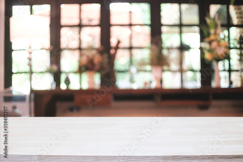 Empty wooden desk space platform and blurred restaurant or coffee shop background for product display montage.