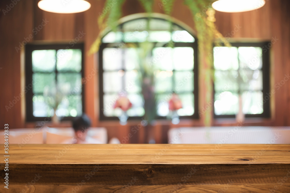 Empty wooden desk space platform and blurred restaurant or coffee shop background for product display montage. Empty wooden desk space platform and blurred restaurant or coffee shop background for product display montage.