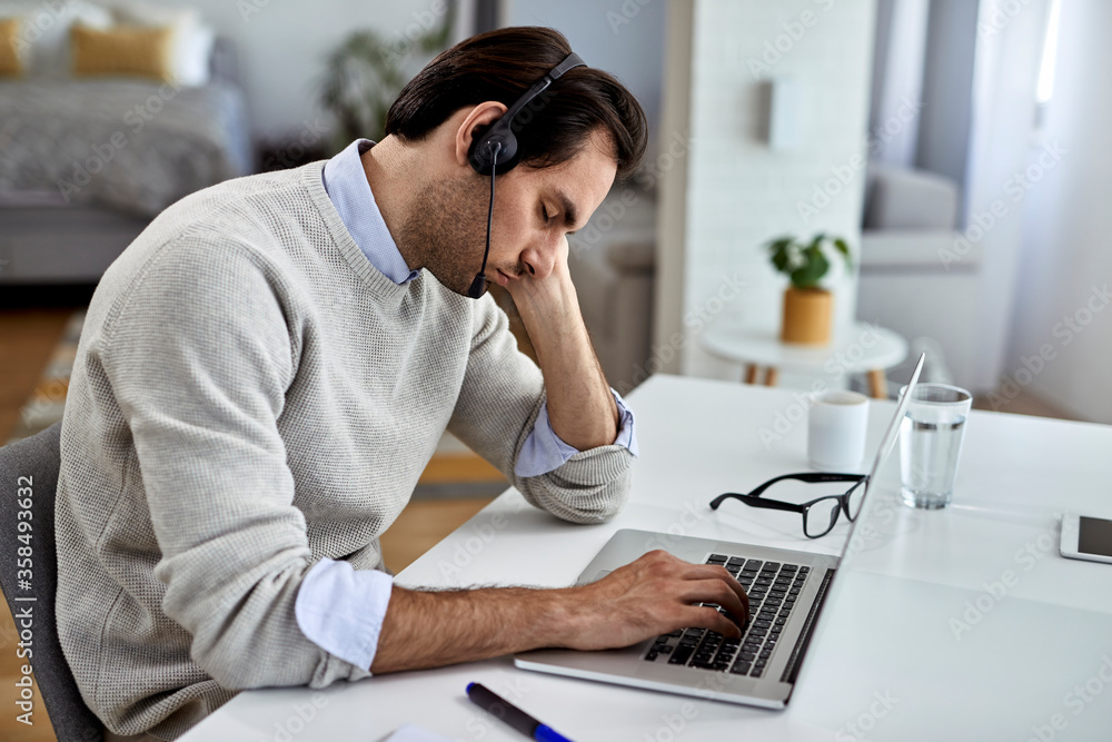 Fototapeta premium Tired businessman fell asleep after working on laptop at home.