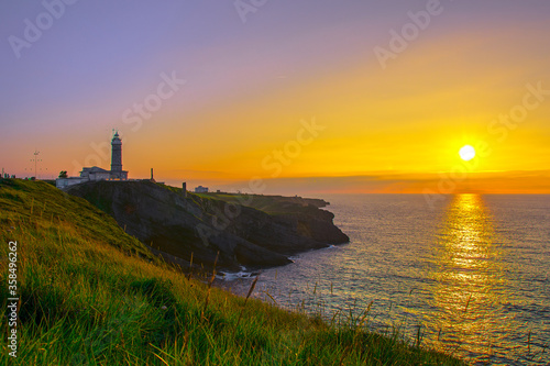 Sunset in the Cabo Mayor lighthouse near city of Santander, Spain, with cliffs, sky and sea. colorful sunset