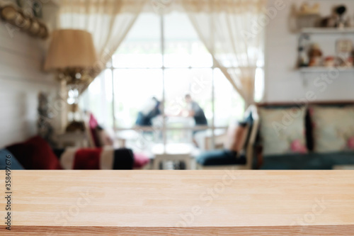 Empty wooden table space platform and blurred restaurant or coffee shop background for product display montage. © qOppi