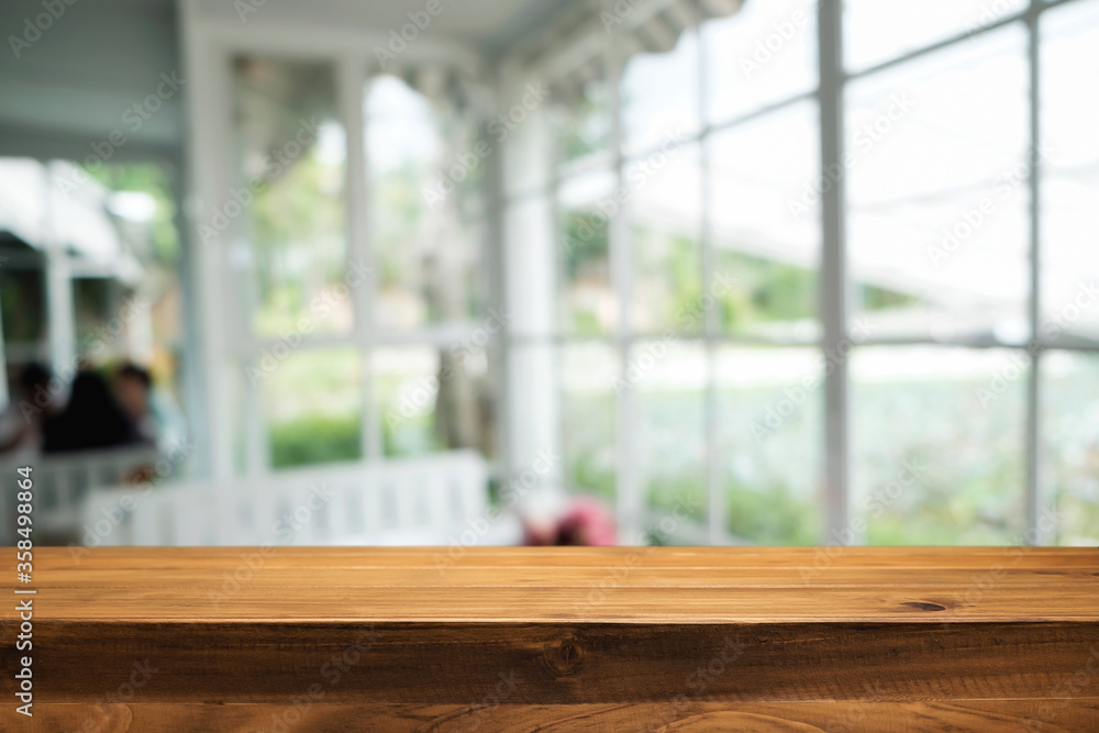 Empty wooden table space platform and blurred restaurant or coffee shop background for product display montage.