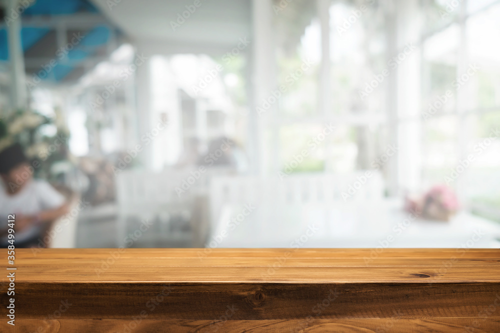 Wooden desk space platform and blurred restaurant or coffee shop background for product display montage. Wooden desk space platform and blurred restaurant or coffee shop background for product display montage.