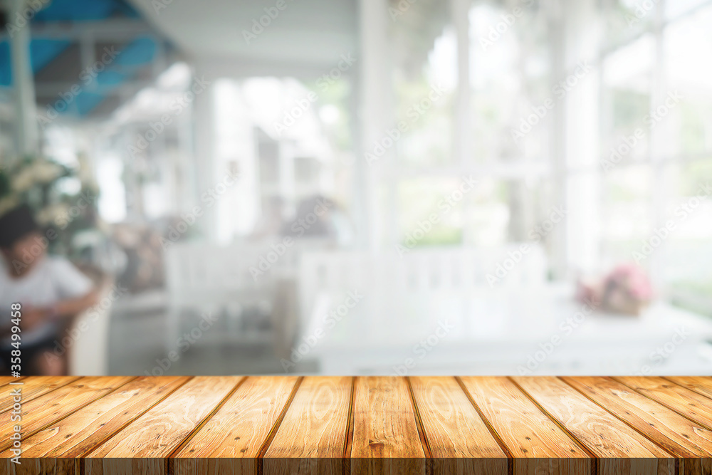 Wooden desk space platform and blurred restaurant or coffee shop background for product display montage.