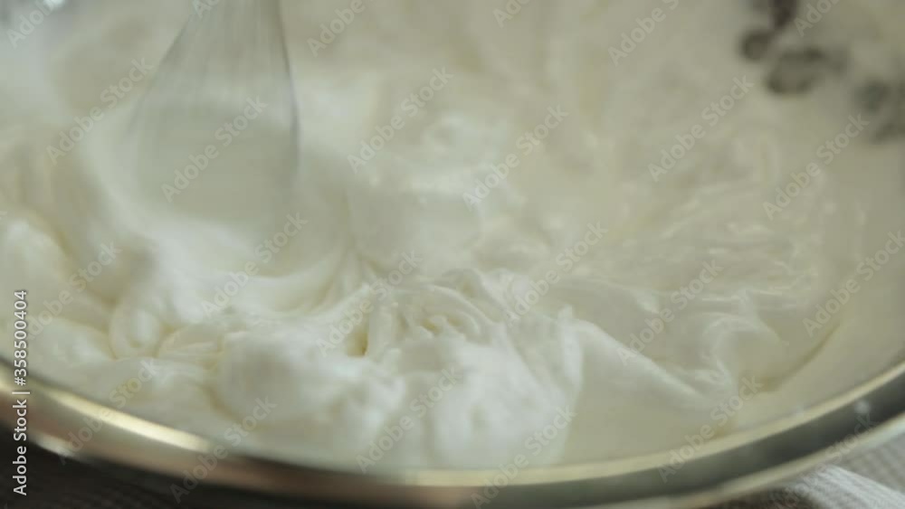 Whipping white cream with a mixer in slow motion. Dessert Pavlova. Whipping white cream with a mixer in slow motion. Dessert Pavlova.