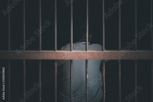 Asian young man arrested in old and dark prison with concept

