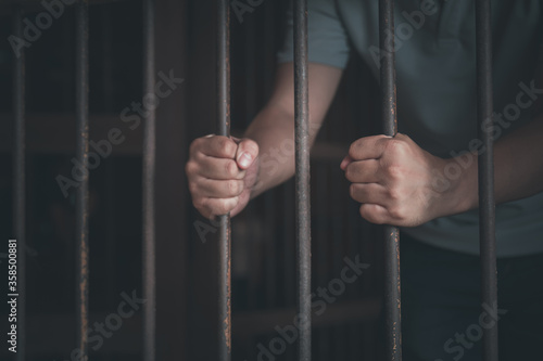 Asian young man arrested in old and dark prison with concept 