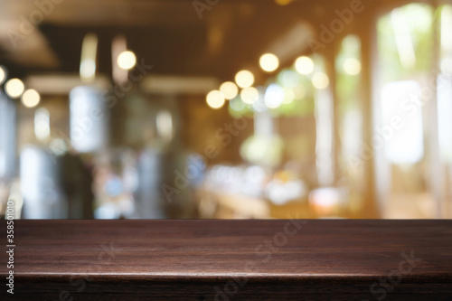Empty wooden table space platform and blurred restaurant or coffee shop background for product display montage.