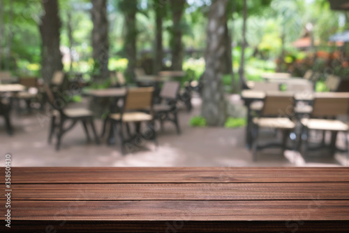 Empty wooden table space platform and blurred restaurant or coffee shop background for product display montage. © qOppi